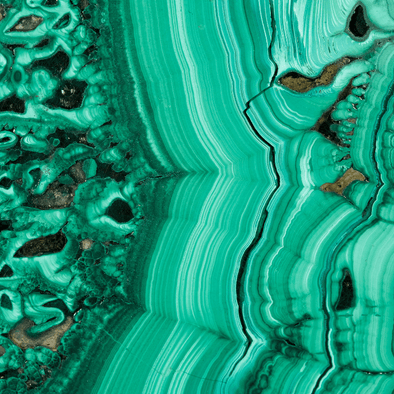 Malachite healing crystal displaying rich green bands, known for its powerful metaphysical properties including emotional healing, protection, and transformation.